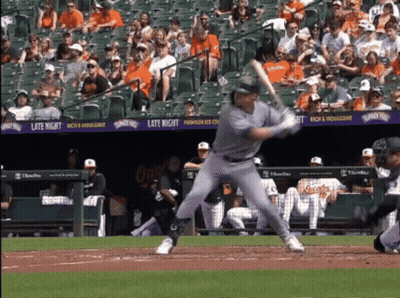 A Baseball Player Swings At A Pitch In Front Of A Banner That Says Late Night On It GIF