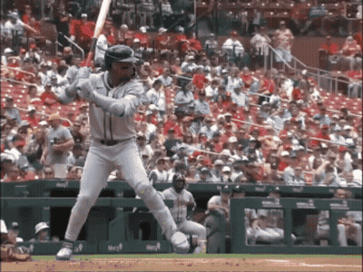 A Baseball Player Swings His Bat At A Ball In Front Of A Crowd Of People GIF