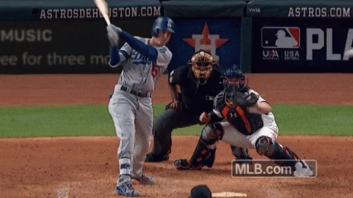 A Baseball Player Swings His Bat At A Pitch While A Catcher Watches GIF