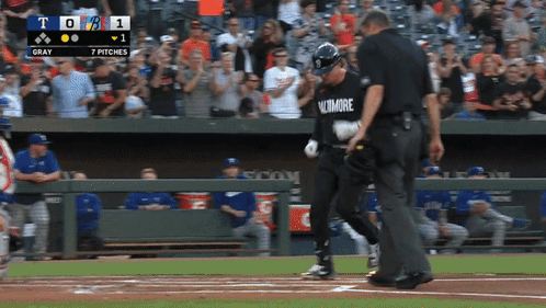 A Baseball Player Wearing A Baltimore Shirt Is Walking Towards The Base GIF