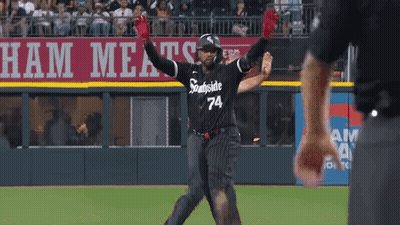 A Baseball Player Wearing A Black And White Uniform With The Number 74 On It GIF