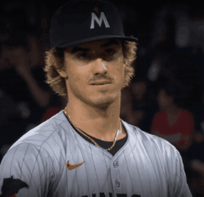 A Baseball Player Wearing A Black Hat With A Letter M On It GIF