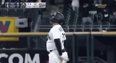 A Baseball Player Wearing A Black Helmet Is Standing On The Field . GIF