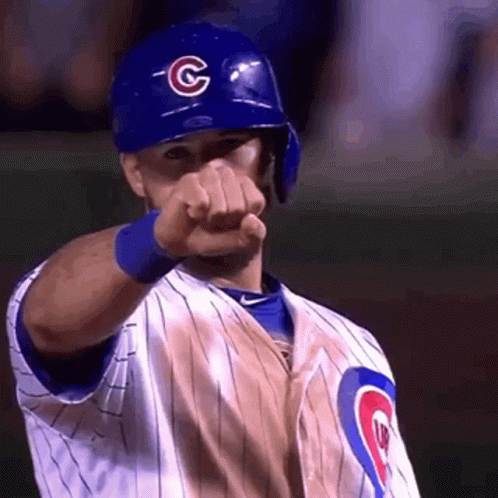A Baseball Player Wearing A Blue Helmet And A Chicago Cubs Uniform Is Pointing At The Camera . GIF
