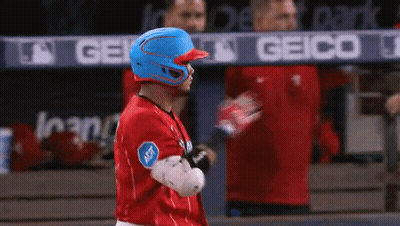 A Baseball Player Wearing A Blue Helmet Is Standing In Front Of A Geico Banner GIF