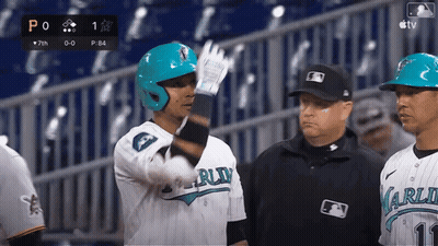 A Baseball Player Wearing A Blue Helmet Is Talking To A Referee GIF