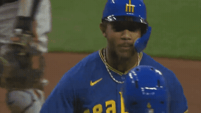 A Baseball Player Wearing A Blue Helmet With A Yellow Letter M On It GIF