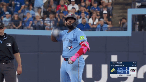 A Baseball Player Wearing A Blue Jays Uniform Is Swinging At A Pitch GIF
