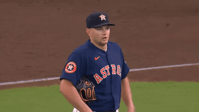 A Baseball Player Wearing A Blue Jersey With The Word Astros On It Is Standing On A Baseball Field . GIF