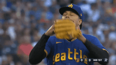A Baseball Player Wearing A Blue Seattle Jersey Holds His Glove GIF