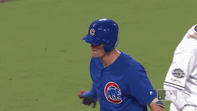 A Baseball Player Wearing A Blue Uniform With A Cubs Logo On It Is Standing On A Field . GIF