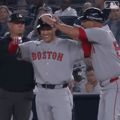 A Baseball Player Wearing A Boston Jersey Is Being Congratulated By Another Player GIF