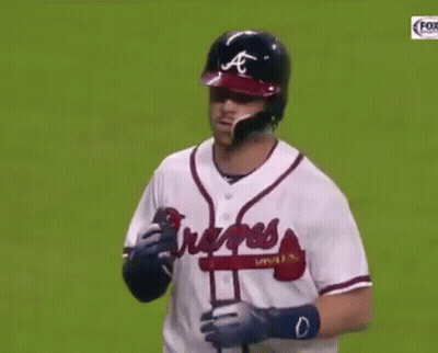 A Baseball Player Wearing A Braves Jersey Holds His Hand To His Face GIF