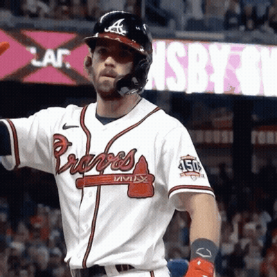 A Baseball Player Wearing A Braves Jersey Is Standing In Front Of A Sign GIF