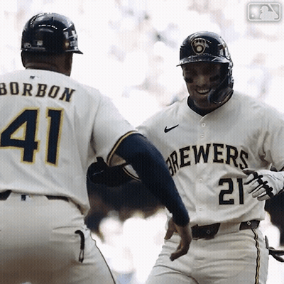 A Baseball Player Wearing A Brewers Jersey Is Congratulating Another Player GIF