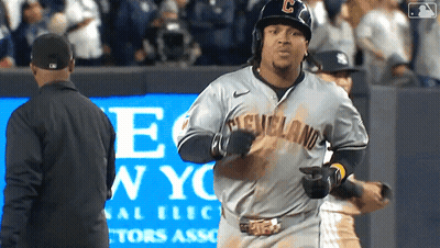 A Baseball Player Wearing A Cleveland Jersey Runs Towards A Man In A Black Jacket GIF