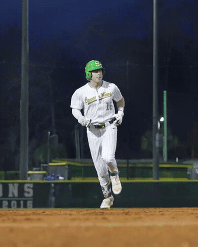 A Baseball Player Wearing A Green Helmet And A White Jersey That Says ' Greenies ' On It GIF