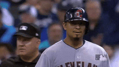 A Baseball Player Wearing A Helmet And A Cleveland Jersey Stands In Front Of A Referee . GIF