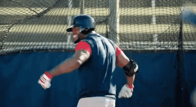 A Baseball Player Wearing A Helmet And Gloves Is Swinging His Bat GIF