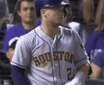 A Baseball Player Wearing A Houston Jersey And A Helmet Is Standing In The Dugout . GIF