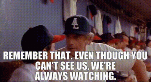 A Baseball Player Wearing A La Hat Is Talking To Another Player In A Dugout . GIF
