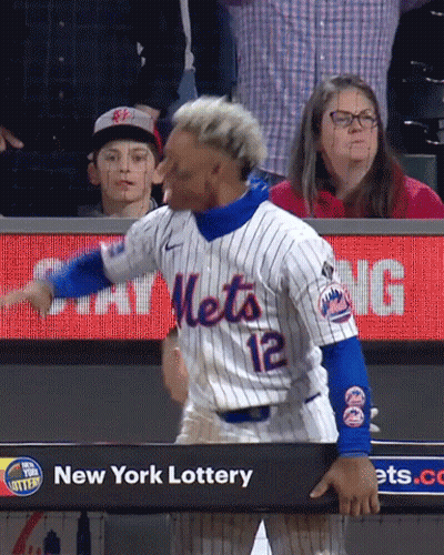 A Baseball Player Wearing A Mets Jersey Is Standing In Front Of A New York Lottery Sign GIF