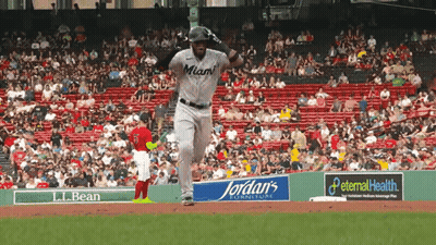 A Baseball Player Wearing A Miami Jersey Is Running Towards The Base GIF