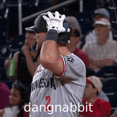 A Baseball Player Wearing A Minnesota Jersey Holds His Helmet Up GIF