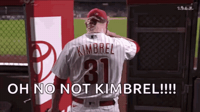 A Baseball Player Wearing A Number 31 Jersey Is Standing In The Dugout . GIF