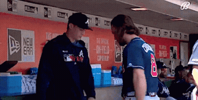 A Baseball Player Wearing A Number 8 Jersey Talks To Another Player In A Dugout GIF