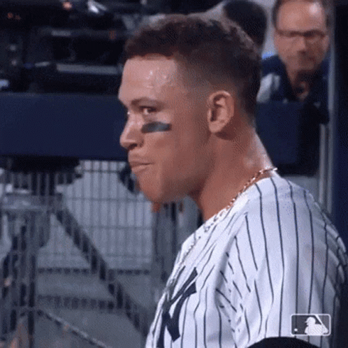 A Baseball Player Wearing A Ny Yankees Jersey Looks To His Left . GIF