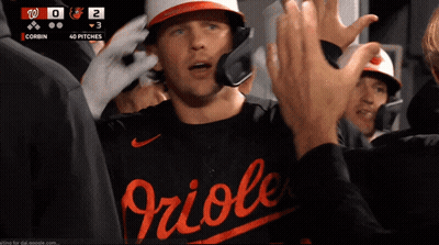 A Baseball Player Wearing A Orioles Jersey High Fives Another Player GIF