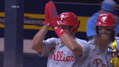 A Baseball Player Wearing A Phillies Jersey Holds Up His Gloves GIF