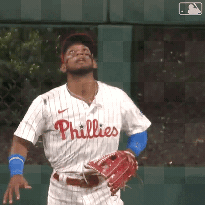 A Baseball Player Wearing A Phillies Jersey Is Looking Up At The Sky GIF