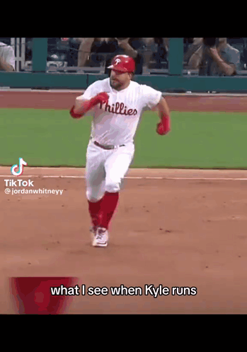 A Baseball Player Wearing A Phillies Jersey Is Running On The Field . GIF
