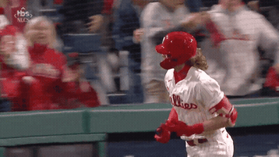 A Baseball Player Wearing A Phillies Jersey Is Running Towards The Dugout GIF