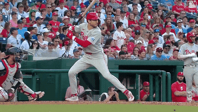 A Baseball Player Wearing A Phillies Jersey Is Swinging At A Pitch GIF