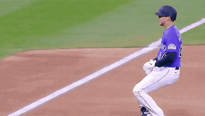 A Baseball Player Wearing A Purple Jersey With The Number 24 On It Is Running Towards The Base . GIF