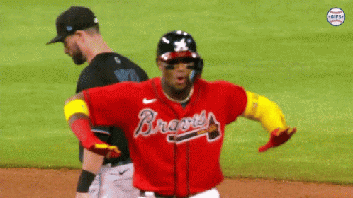 A Baseball Player Wearing A Red Braves Jersey Is Running On The Field GIF