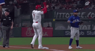 A Baseball Player Wearing A Red Helmet Is Standing In Front Of A Blue Player . GIF