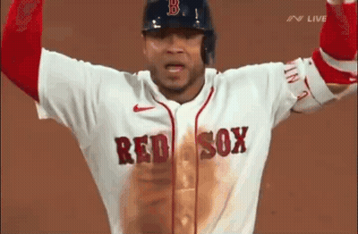 A Baseball Player Wearing A Red Sox Jersey Is Standing On A Field With His Arms In The Air . GIF