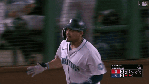 A Baseball Player Wearing A Seattle Mariners Jersey Runs Towards Home Plate GIF