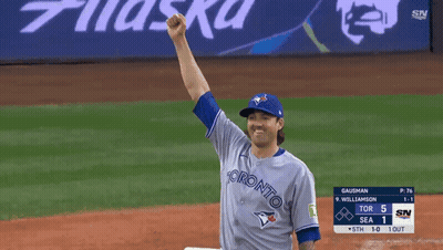 A Baseball Player Wearing A Toronto Jersey Holds His Fist Up In The Air GIF