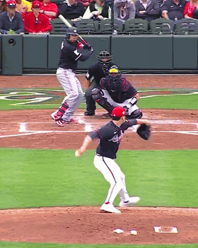 A Baseball Player Wearing A Washington Nationals Jersey Is About To Swing At A Pitch GIF