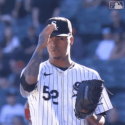 A Baseball Player Wearing A White And Black Uniform With The Number 52 On It GIF