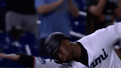 A Baseball Player Wearing A White Jersey With Miami On It GIF