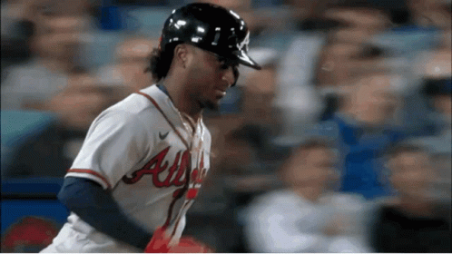 A Baseball Player Wearing An Atlanta Uniform Looks Down At Something GIF