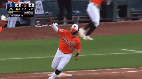 A Baseball Player Wearing An Orange Orioles Jersey Runs To First Base GIF