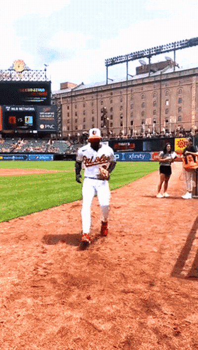 A Baseball Player Wearing An Orioles Uniform Is Running Towards The Bases GIF