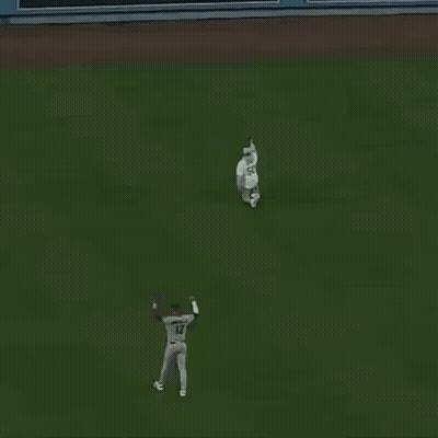 A Baseball Player With The Number 12 On His Jersey Stands On The Field GIF